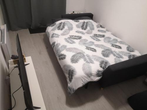 een bed in een kamer met een deken erop bij Maison à 500 m du lac in Ardres