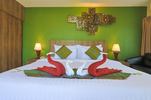 a bedroom with a bed with two swans on it at The Gig Hotel in Patong Beach