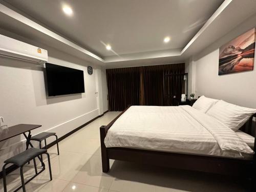 um quarto com uma cama e uma televisão de ecrã plano em Chris Jay @ CNX em Chiang Mai