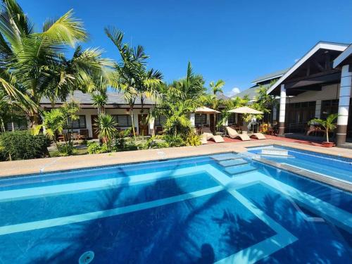 a swimming pool in front of a house at Marand Beach Resort in Bauang
