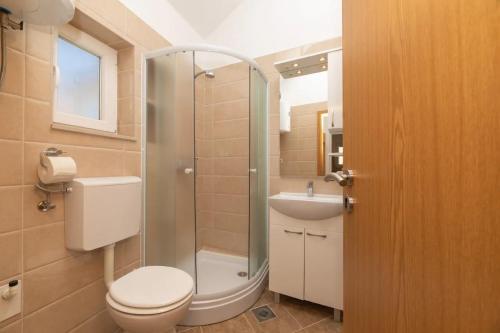 een badkamer met een douche, een toilet en een wastafel bij Apartments Stone garden - cosy and comfy in Supetar