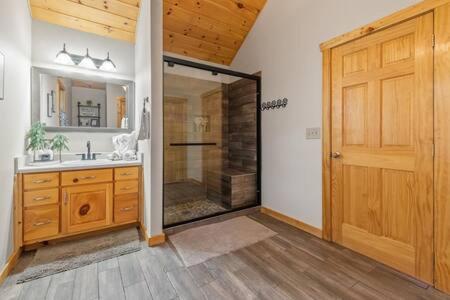 a bathroom with a shower and a wooden door at Best Views in Ellijay - Waffle Bar-King Bed-HotTub in Ellijay