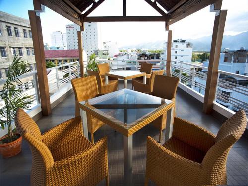 Un patio con sillas y una mesa en el balcón. en NhaTrang Luxury Serviced Apartment, en Nha Trang