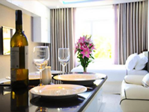 una mesa de comedor con una botella de vino y copas de vino en NhaTrang Luxury Serviced Apartment, en Nha Trang