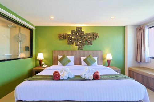 a bedroom with a large white bed with towels on it at The Gig Hotel in Patong Beach