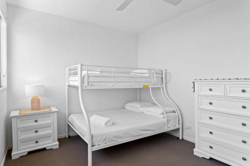 - un lit superposé blanc avec une commode blanche dans l'établissement 3-Bed Beach Haven with Patio, BBQ & Secure Parking, à Scarborough