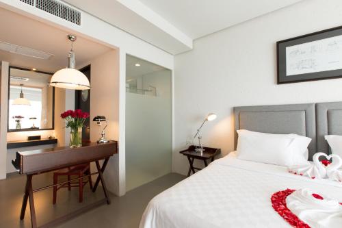 a bedroom with a bed and a desk and a desk at Sugar Palm Grand Hillside - SHA Plus in Kata Beach