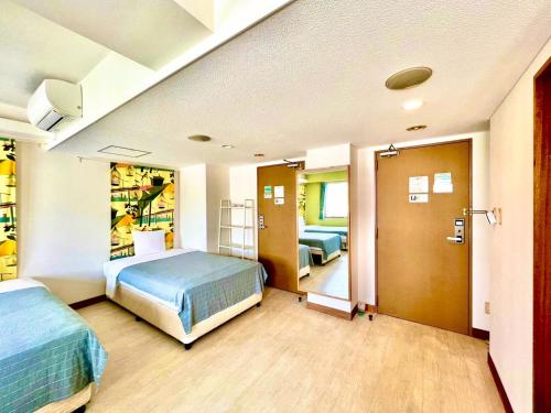 ein Krankenhauszimmer mit 2 Betten und einem Flur in der Unterkunft Hotel Happy Holiday Ishigakijima - Vacation STAY 04026v in Ishigaki-jima