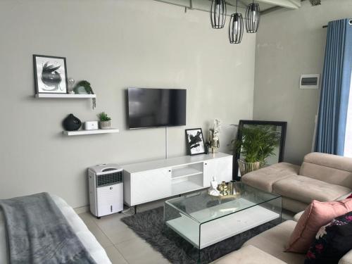 sala de estar con sofá y TV en Moraswi Apartment on 31 Forest Road, en Johannesburgo