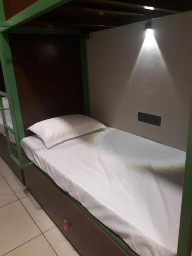 un letto a castello verde con un cuscino bianco di CosyCove a Ernakulam