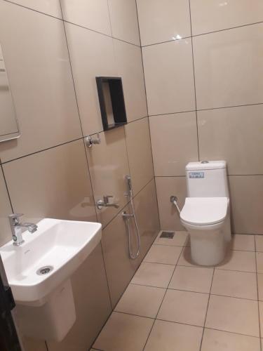 La salle de bains est pourvue de toilettes et d'un lavabo. dans l'établissement CosyCove, à Ernakulam