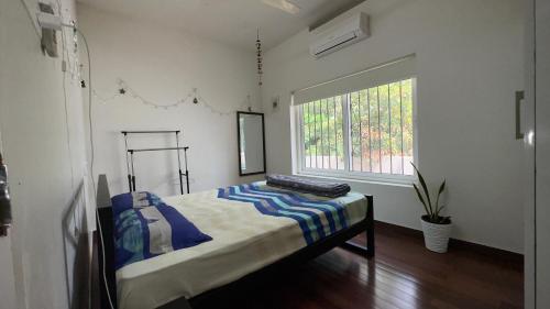 een slaapkamer met een bed in een kamer met een raam bij Lux Home Trivandrum in Trivandrum