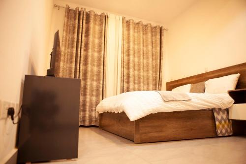 ein kleines Schlafzimmer mit einem Bett und einem Fenster in der Unterkunft Kigali Homes Villa in Kigali