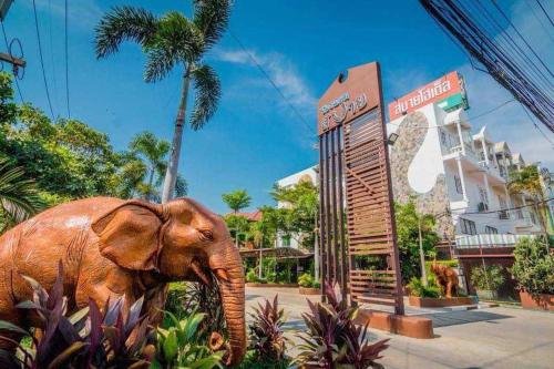 un elefante parado frente a un hotel en โรงแรมสบายโฮเต็ล 