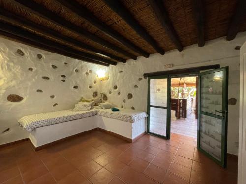 a bedroom with a bed and a wall with rocks at Country Home with horses in Telde in Ojos de Garza