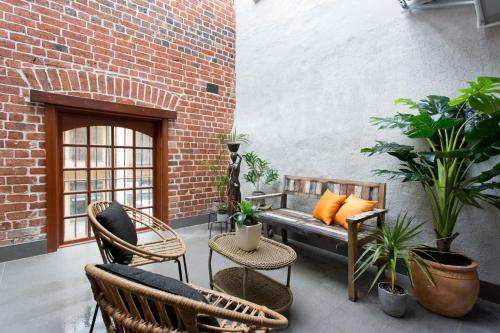 a patio with a bench and chairs and plants at Windows on Pakenham-Hip art space in the West End in Fremantle
