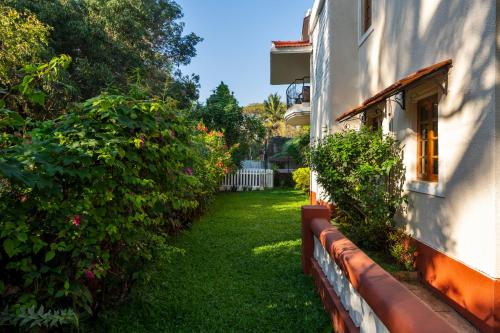 a yard next to a house with a fence at Beachside Bliss Villas Candolim 10 min walk from Sinquerim Beach in Sinquerim