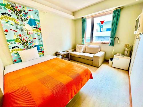 ein Schlafzimmer mit einem farbenfrohen Bett und einem Sofa in der Unterkunft Hotel Happy Holiday Ishigakijima - Vacation STAY 04143v in Ishigaki-jima