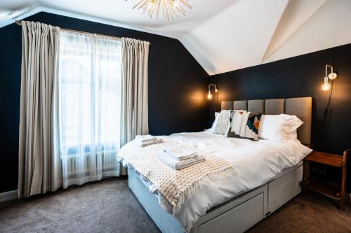 1 dormitorio con 1 cama grande y pared negra en Stay with airhgt at 3 bedroom house near The Stray en Harrogate