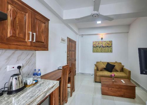 a kitchen and a living room with a couch at Kerawalapitiya Resort in Mahabage