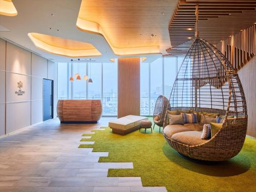 a living room with a swing hanging from the ceiling at HOTEL AlaCOOJU OKINAWA in Urasoe
