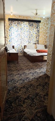 - une chambre avec 2 lits et une fenêtre dans l'établissement Hotel Kashmir Heaven, à Srinagar