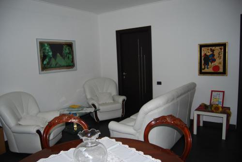 a room with three white chairs and a table with a table at Casa MaMa Guesthouse in Genova