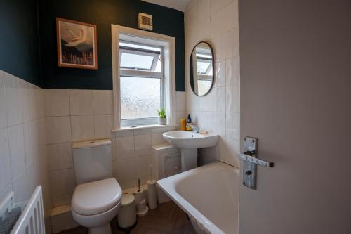 a bathroom with a toilet and a sink and a tub at Stay with airhgt @ Luxe Apartment in Central Harrogate in Harrogate