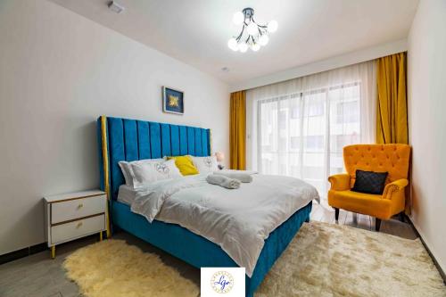 sypialnia z niebieskim łóżkiem i żółtym krzesłem w obiekcie Queens&Kings Garden w mieście Nairobi