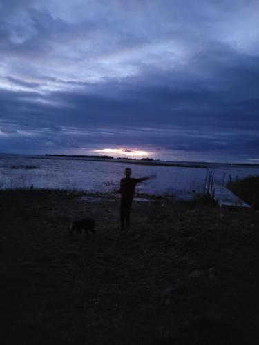 a man and a dog standing in front of the water at The Cove in Little Current