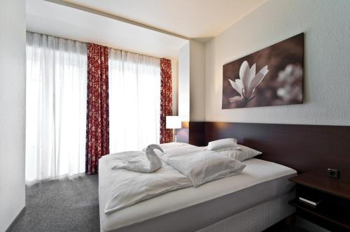 a bedroom with a bed and a large window at Hotel am Oppspring in Mülheim an der Ruhr