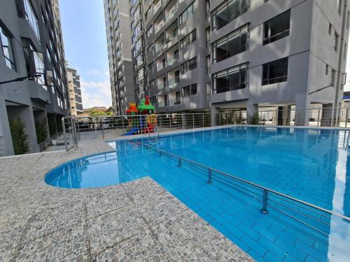 a large blue swimming pool in front of a building at Queens&Kings Garden in Nairobi