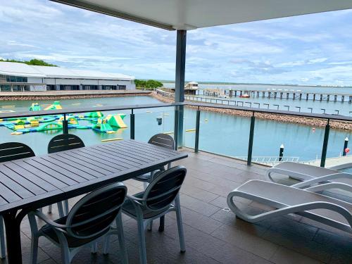 a balcony with a table and chairs and a swimming pool at Serenity Neptuna - 3brm luxury at Darwin Waterfront in Darwin