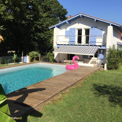 una piscina con un flamenco rosa frente a una casa en Chambre chez l’habitant, en Anglet