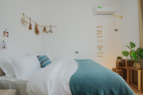 a bedroom with a white bed with a green blanket at Yangshuo Jing Yuan Inn Near The West Street in Yangshuo