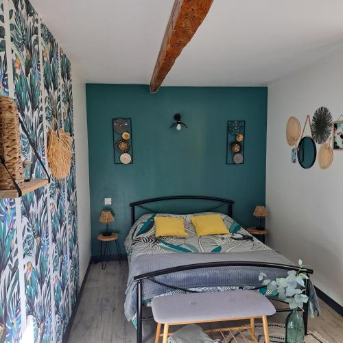 une chambre avec un lit et un mur bleu dans l'établissement Le Domaine Vesque, à Saint-Pierre-de-Clairac