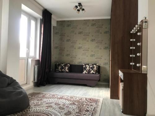 ein Wohnzimmer mit einem Sofa und einem Fenster in der Unterkunft Квартира in Almaty