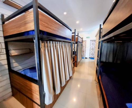 a room with bunk beds and a curtain at Back Home Backpackers in Bangkok