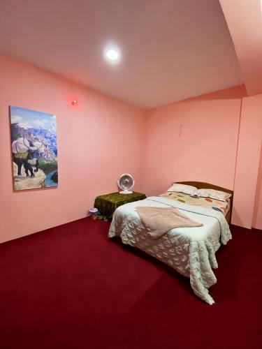 a bedroom with a bed and a painting on the wall at Devanagari Home in Dahachok