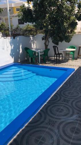 ボカ・チカにあるPremium Pool Houseの青いスイミングプール(テーブル、椅子付)