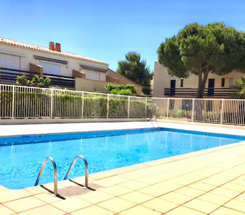 une piscine devant un immeuble dans l'établissement Cap d'Agde Les Estivales, au Cap d'Agde
