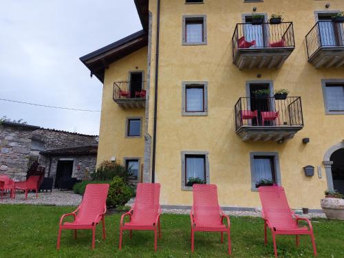 a group of red chairs in front of a building at Residence Samont in Arta Terme