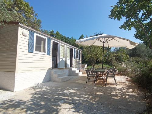 a patio with an umbrella and a table and chairs at Hillbilly cabin, 2 studios in nature with terrace and parking in Skiathos