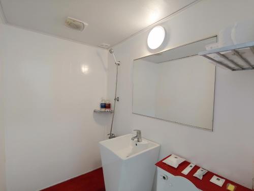 a white bathroom with a sink and a mirror at Star House in Jeju