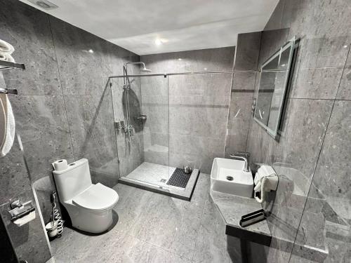 uma casa de banho com um chuveiro, um WC e um lavatório. em HUSMA Hotel & Spa em Tashkent