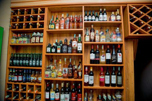 a shelf filled with lots of bottles of alcohol at ANINY HOTEL in Dar es Salaam