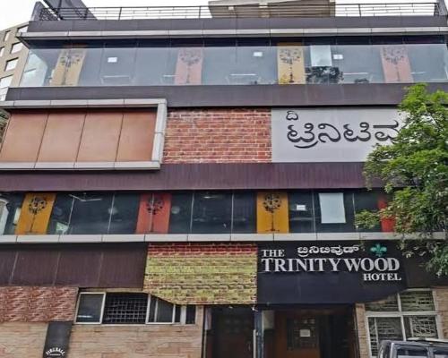 バンガロールにあるThe Trinitywood Hotel & Restaurantのシニティ ウッドホテルの看板のある建物