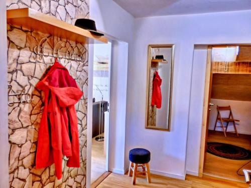Zimmer mit einer Steinmauer und roten Bademänteln. in der Unterkunft PENTHOUSE with mountain views and SAUNA in Hermagor
