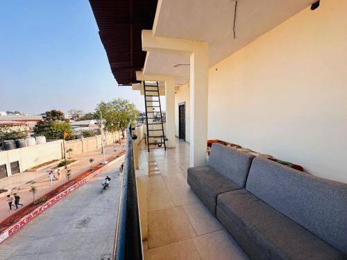 balcón con sofá y vistas a la calle en Tiwari G Shridhara Hotel, en Ujjain