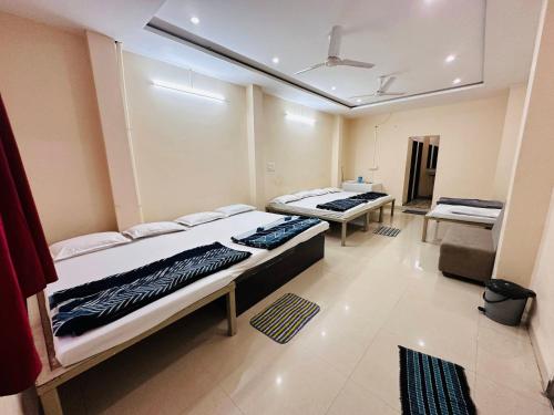 a room with two beds in it with a ceiling at Tiwari G Shridhara Hotel in Ujjain